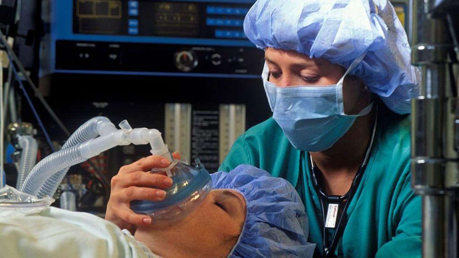 Anestesista administrando sedação a paciente, em um centro cirúrgico